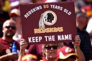 Torcedor do Washington Redskins segura cartaz pedindo pela manutenção do nome