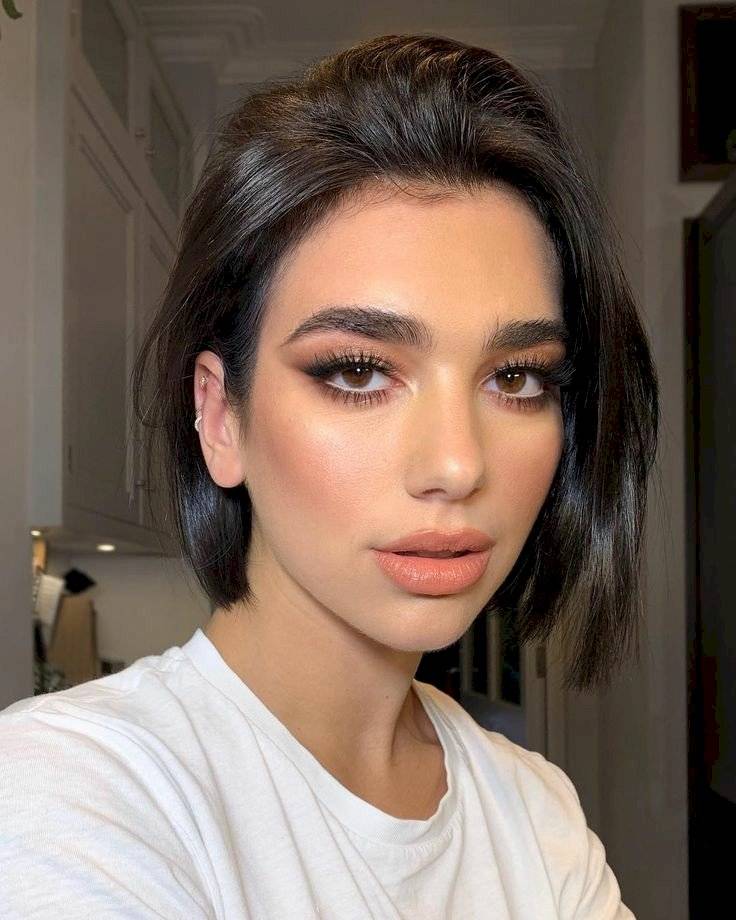 Dua Lipa sorprende al regresar a su look de morena con un elegante body blanco que abraza su delgada cintura