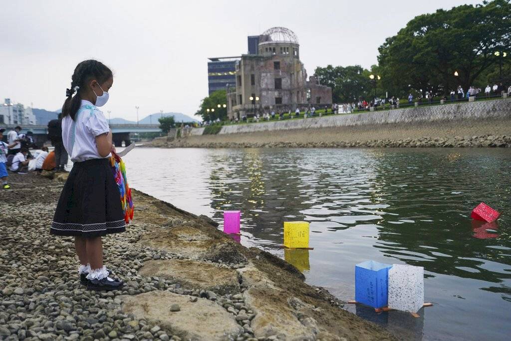 Saki Morioki, de 5 años, observa las linternas de papel que flotan a lo largo del río Motoyasu frente a la Cúpula de la Bomba Atómica. El evento oficial de las linternas fue cancelado debido al Covid-19