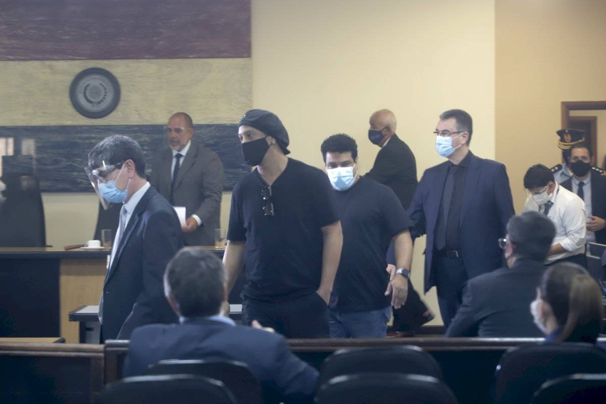 Ronaldinho y su hermano Roberto Assís, centro a la derecha, ingresan para una audiencia en el Palacio de Justicia de Asunción
