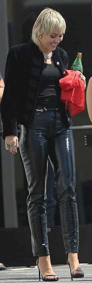 Miley Cyrus se ve glamorosa en un pantalón de látex negro y chaqueta de terciopelo estilo militar