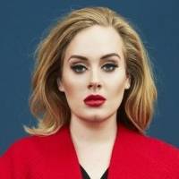 Adele hechiza con blusón de pliegos y medias de malla negra con suecos de madera