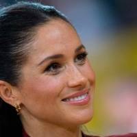Meghan Markle con un vestido asimétrico plisado y un maxi blazer blanco enseña cómo elegante en blanco y negro