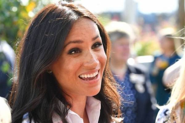 Meghan Markle deslumbra en un vestido vino tinto de gamuza con botines y un maxi abrigo invernal