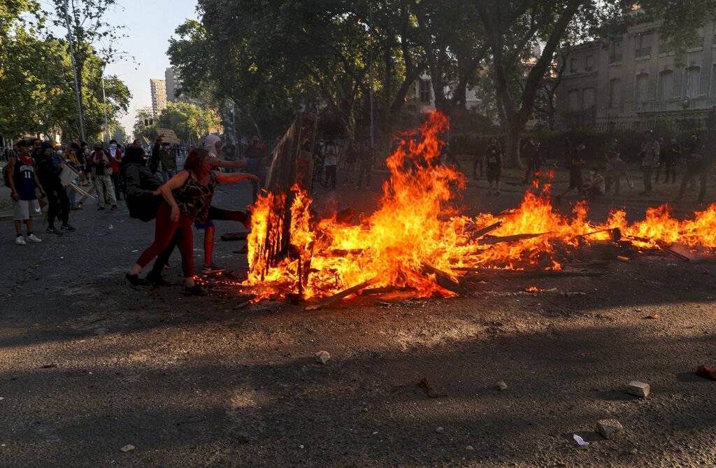 Manifestantes contra el gobierno prenden fuego a una barricada en Santiago de Chile el viernes 16 de octubre de 2020.