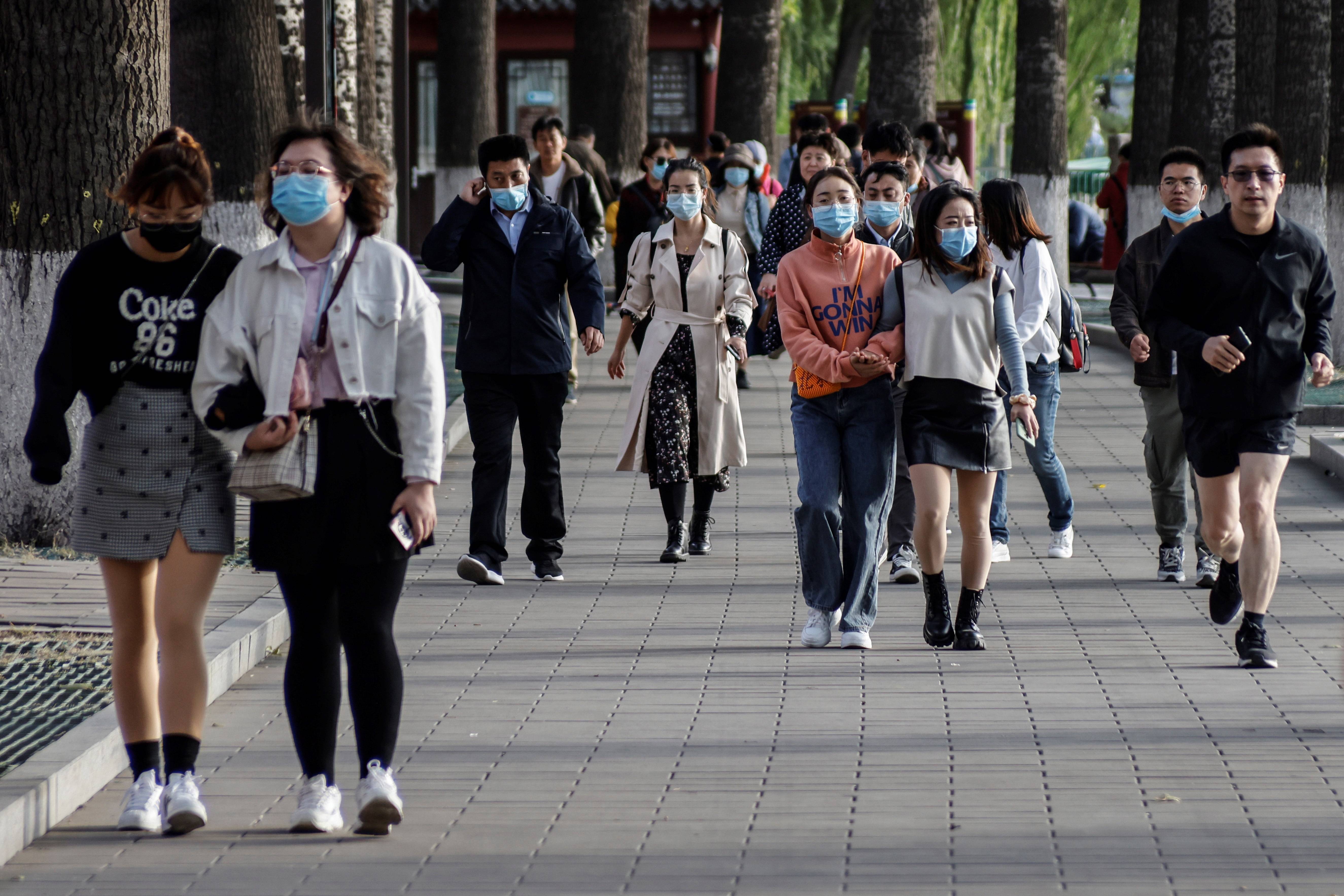 Personas con máscaras protectoras caminan por el parque Beihai en medio de la pandemia de coronavirus en Beijing