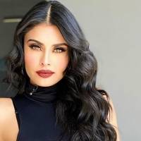 Kristal Silva luce hermosa en blusa blanca off-shoulder y elegante falda lápiz negra
