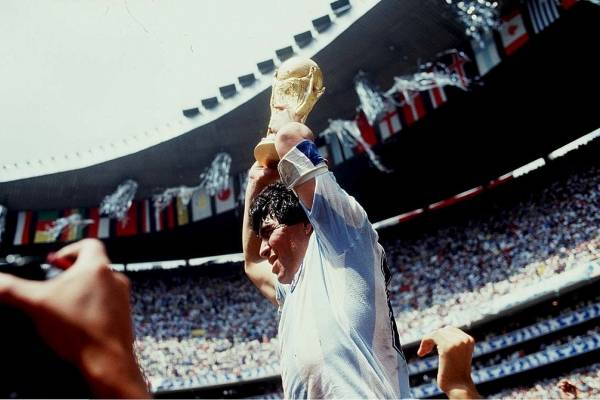 Diego Armando Maradona futbolista, la bandera de Argentina por el mundo y el santo de Nápoles