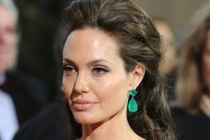 Angelina Jolie elige el blanco para deslumbrar en un vestido escotado de seda con plumas de avestruz