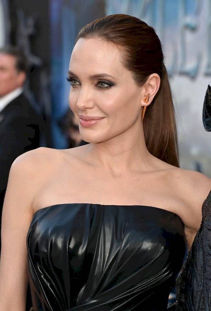 Angelina Jolie elige el blanco para deslumbrar en un vestido escotado de seda con plumas de avestruz