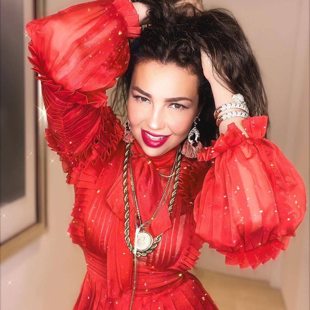 Thalia se luce en Navidad con un outfit de gala en un romántico vestido rojo plisado que eleva su elegancia thalia