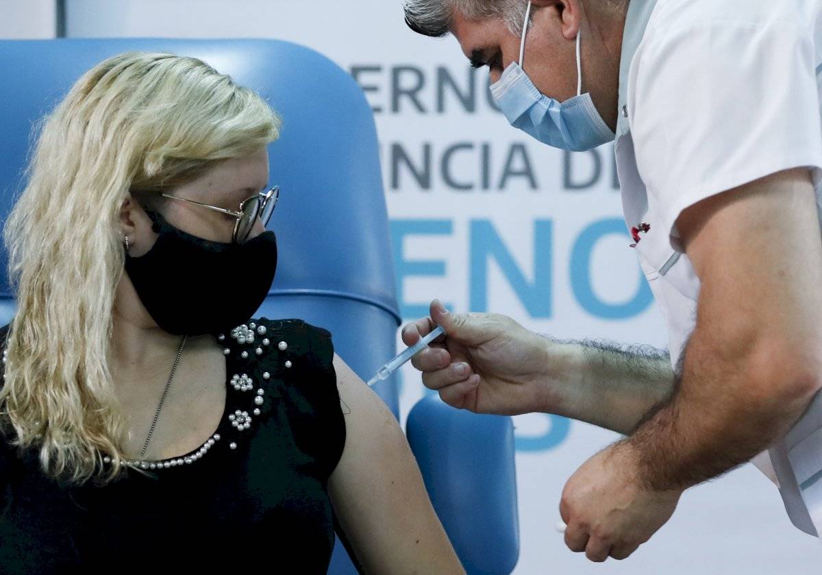 El enfermero Gustavo Rodríguez le da a la enfermera Florencia Arroyo una inyección de la vacuna rusa Sputnik V para el COVID-19