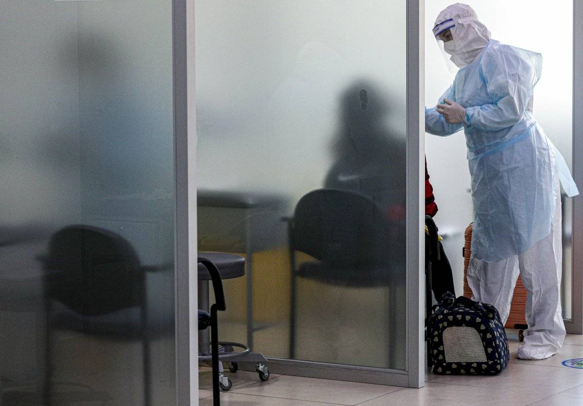 Una trabajadora sanitaria toma una muestra nasal para hacer una prueba de COVID-10 a un pasajero llegado al aeropuerto internacional Arturo Merino Benítez en Santiago de Chile