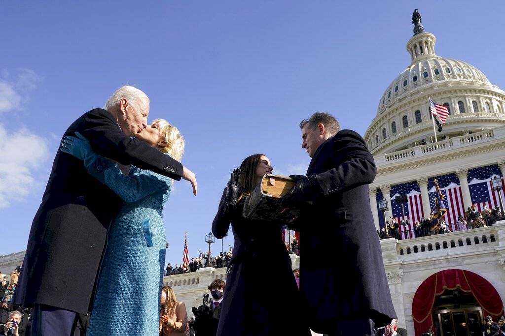 El presidente Joe Biden besa a la primera dama Jill Biden. Le acompañan sus hijos Hunter y Ashley Biden