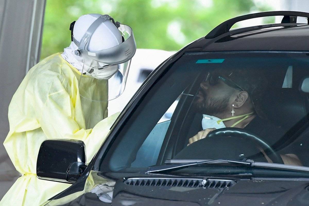 Un trabajador de la salud examina a las personas en una clínica de pruebas de detección de COVID-19 en Murarrie en Brisbane