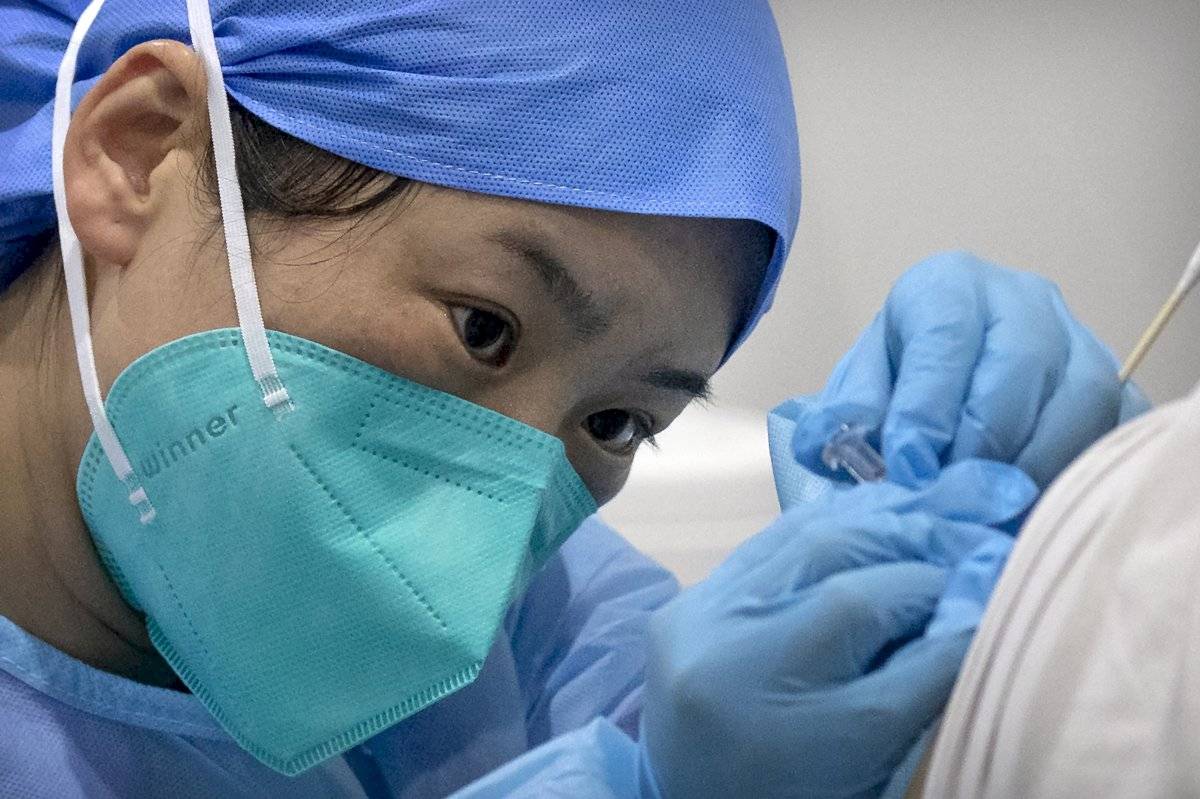 Un trabajador médico aplica una vacuna contra el coronavirus a un paciente en un centro de vacunación en Beijing