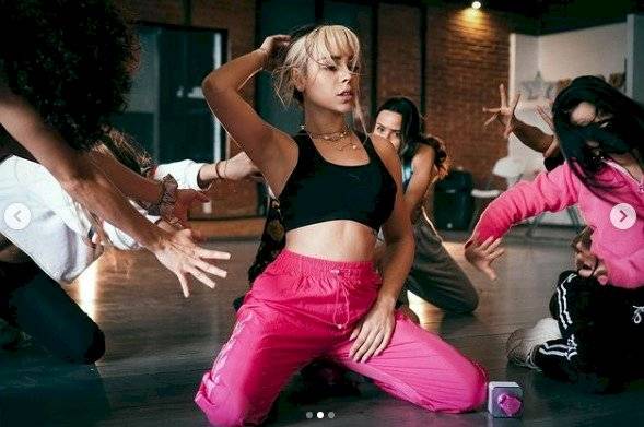 Danna Paola en top deportivo negro y pants fucsia